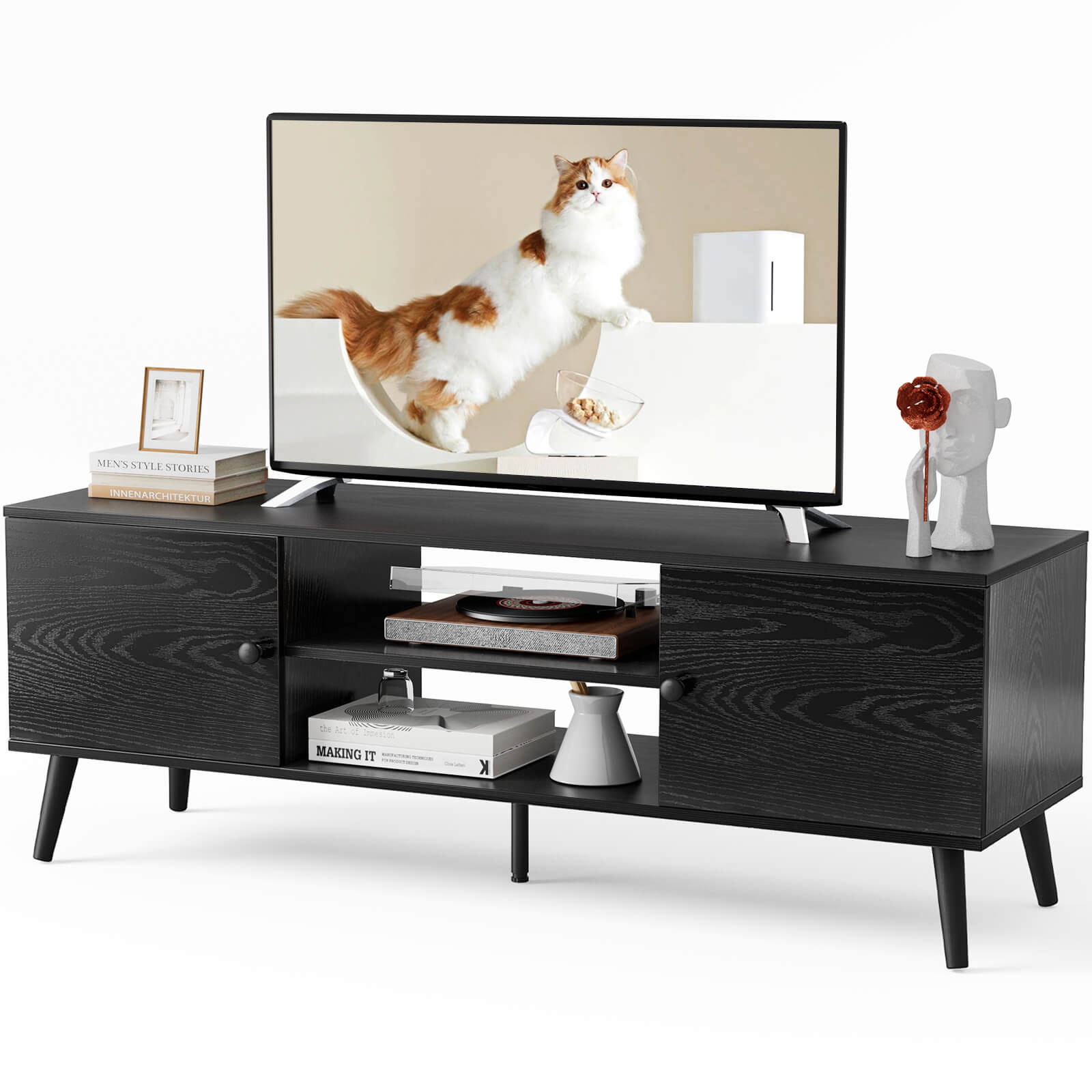 A black TV stand with a TV on top and various items on top.
